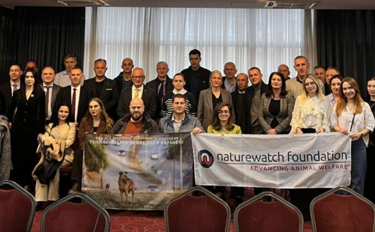Conference attendees holding Naturewatch Foundation banner