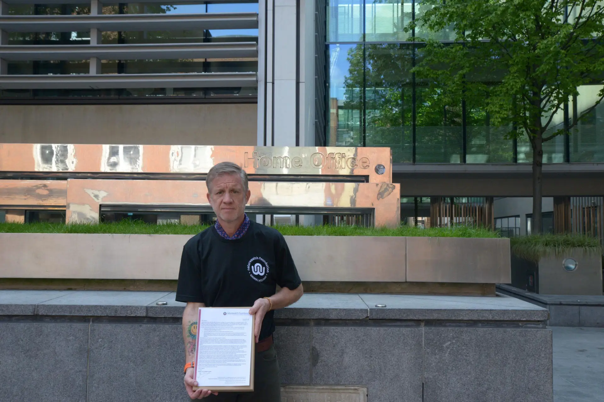 Jim stood outside the home office holding a box of letters.